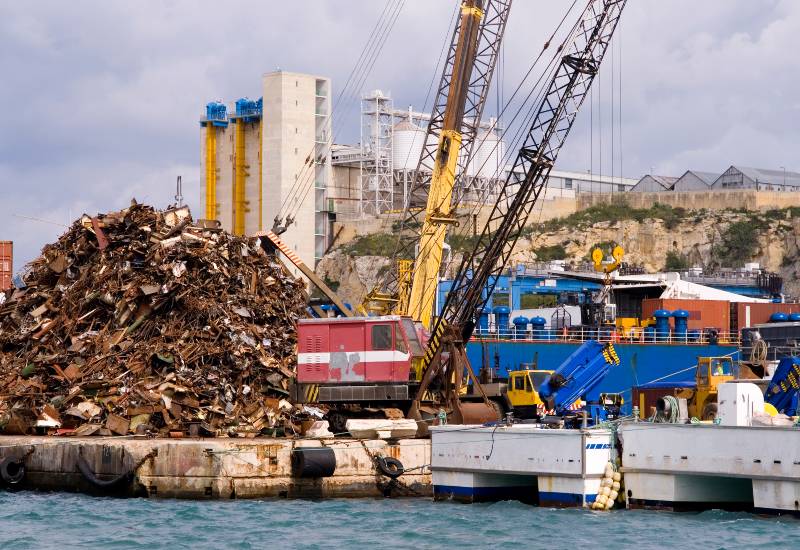 Industrial site with cranes and a large pile of scrap metal in Vancouver, BC