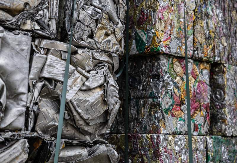 Baled scrap aluminum metal blocks stacked inside a metal recycling plant in Vancouver, BC