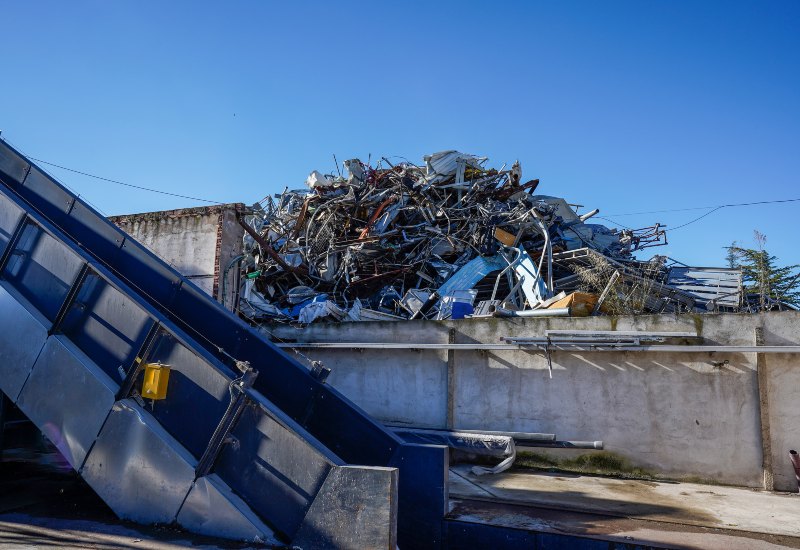 Industrial scrap metal pile with conveyor system at recycling facility in Vancouver, BC
