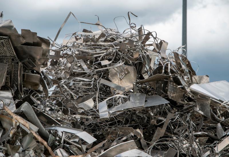 Pile of mixed scrap metal sheets and industrial metal waste at recycling yard in Vancouver, BC